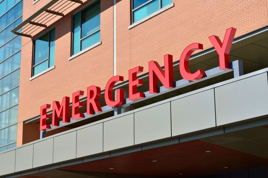 Large red EMERGENCY sign on the exterior of a hospital emergency department